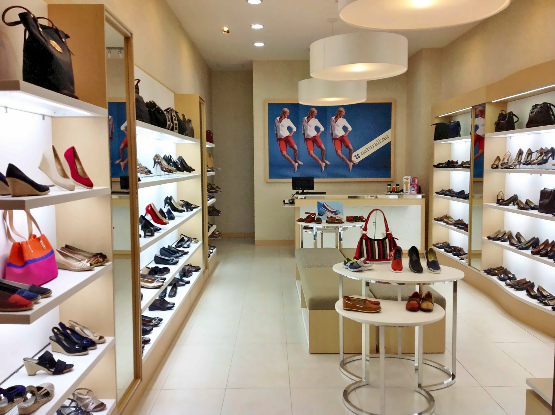 Inside the Lima store: lit wall shelving and a round display table