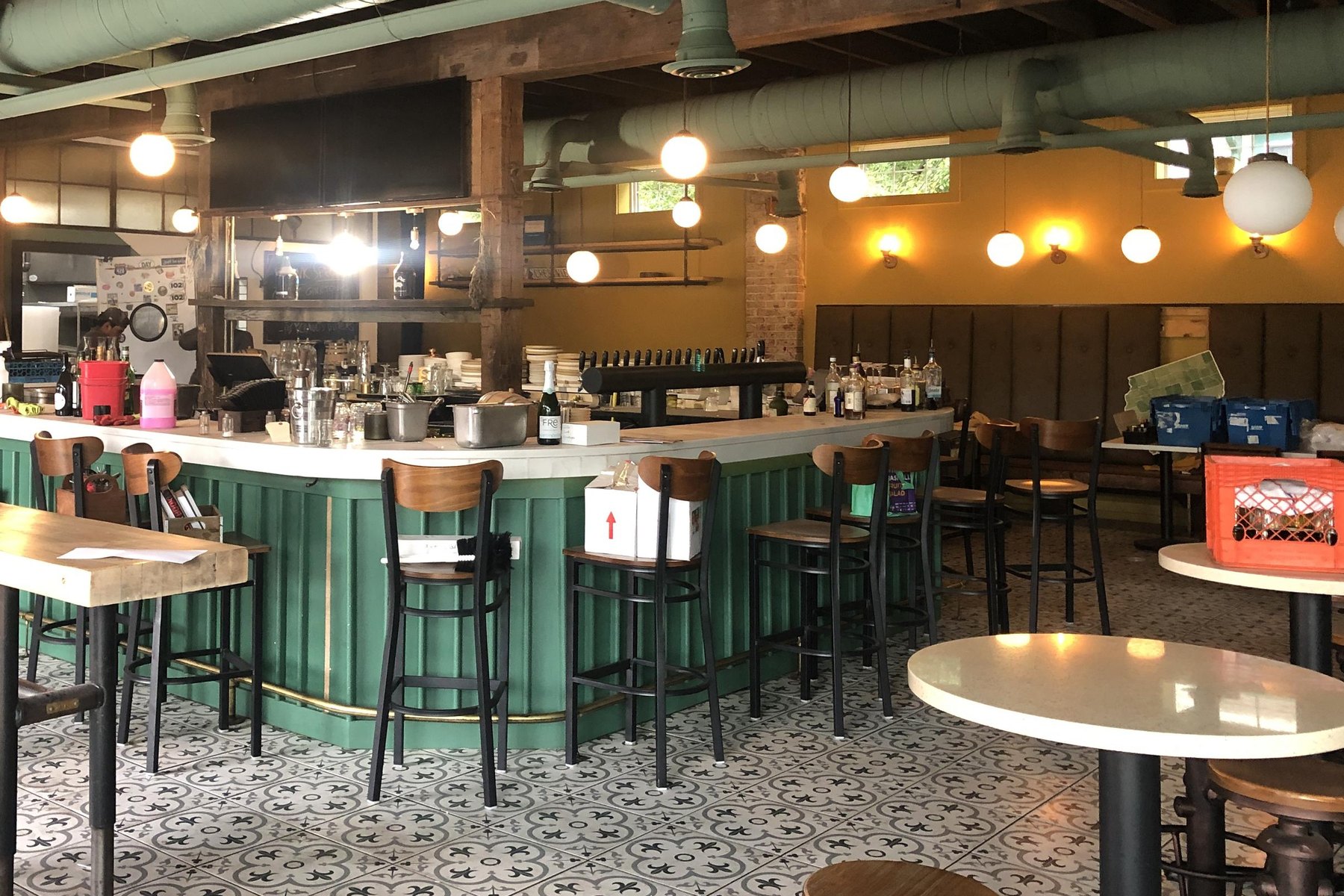 The space before the remodel: a green bar under green ducts and a plain yellow back wall