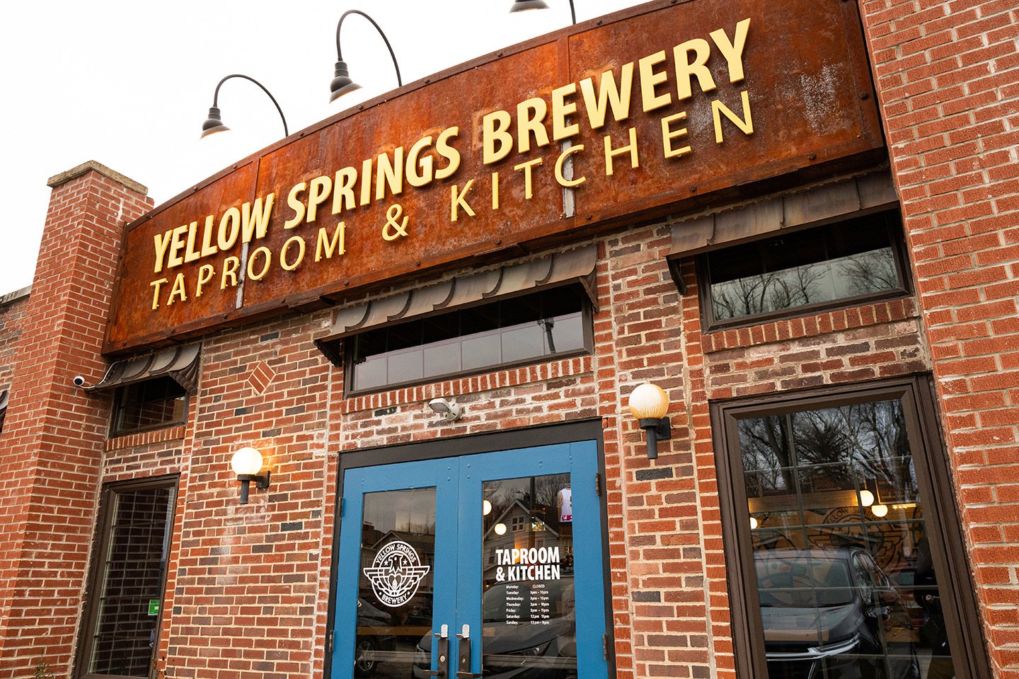 The brick front of the Yellow Springs Brewery Taproom & Kitchen with blue doors