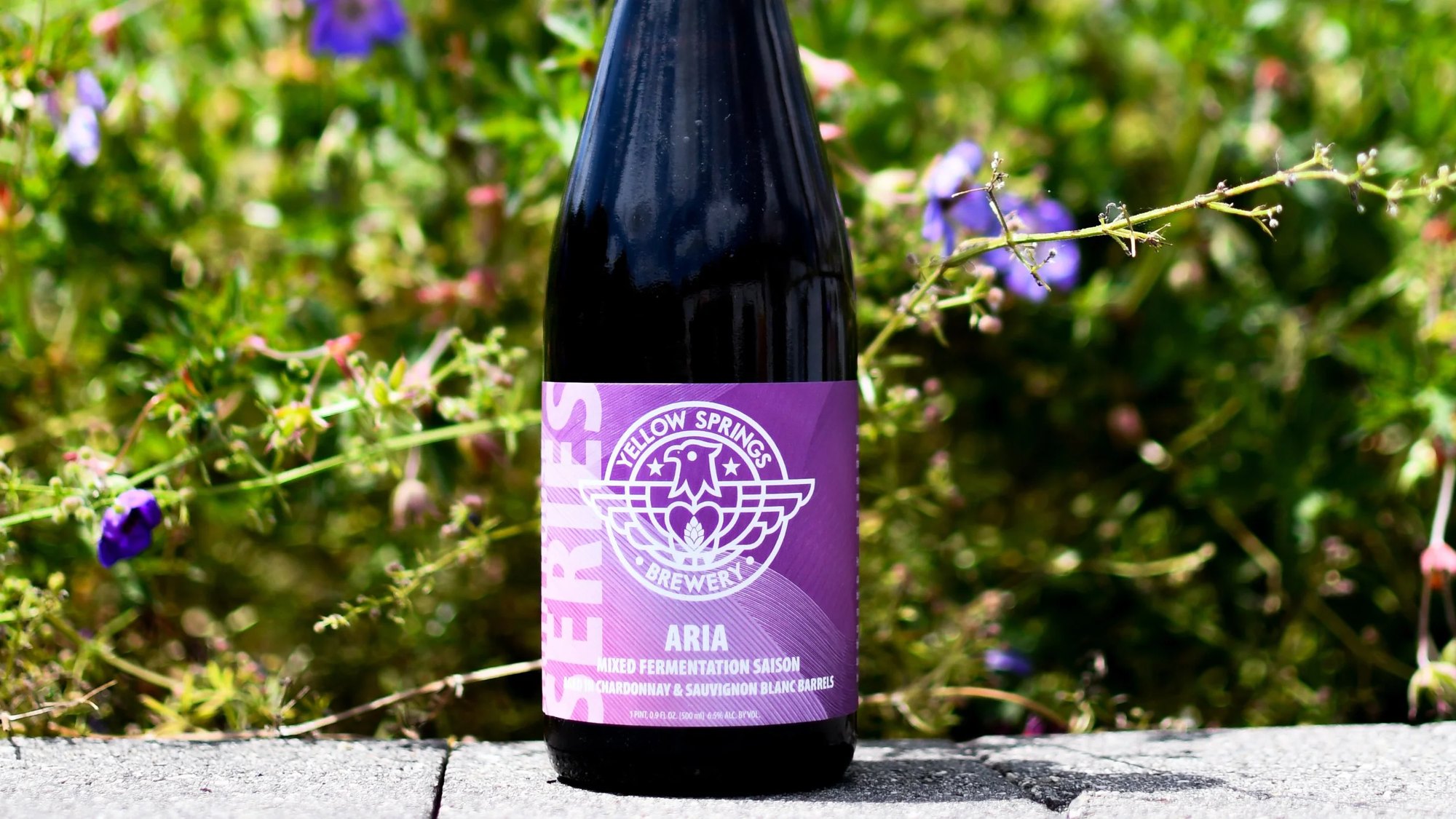Aria bottle among purple wildflowers