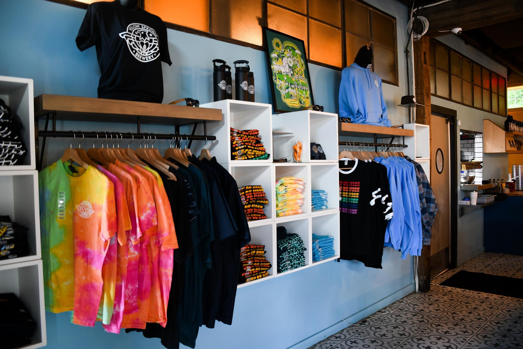 The finished merchandise wall, stocked with brewery shirts, hoodies and gear