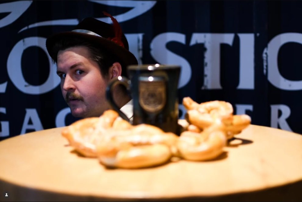 Elliot Cromer peeks over a plate of pretzels and a stein